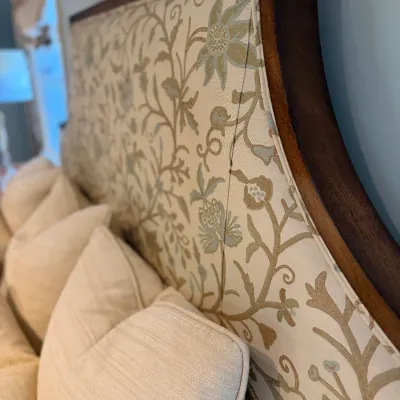 Sale Photo Thumbnail #80: Traditional upholstered headboard featuring a dark wood frame and a botanical jacquard fabric panel in neutral tones.
