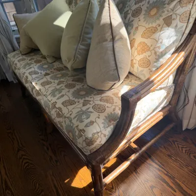 Sale Photo Thumbnail #67: Dark rattan loveseat featuring a botanical patterned floral fabric cushion set and four coordinating accent pillows.