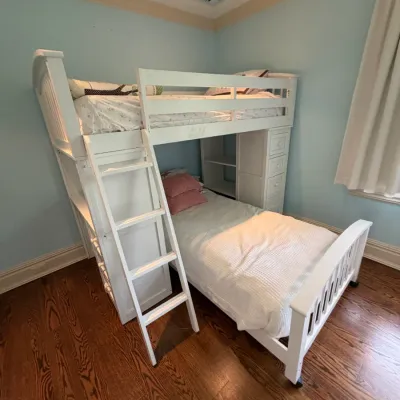 Sale Photo Thumbnail #150: Modern white wooden loft bunk bed unit featuring an integrated ladder, storage drawers, and open shelving.