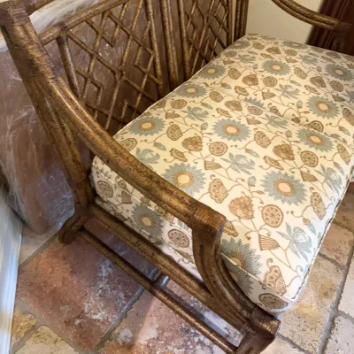 Sale Photo Thumbnail #199: Faux-bamboo or rattan loveseat with open lattice-back design and upholstered floral seat cushion.