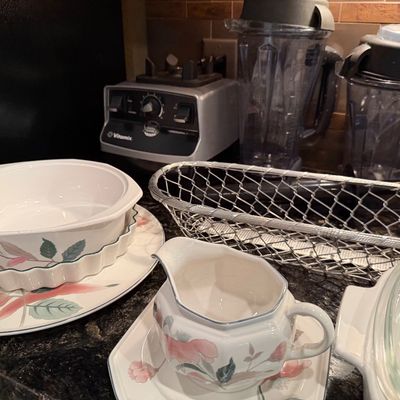 Sale Photo Thumbnail #45: Selection of kitchenware including Mikasa Garden Harvest floral stoneware pieces, a metallic wire mesh basket, and a silver Vitamix Professional Series blender with two containers.