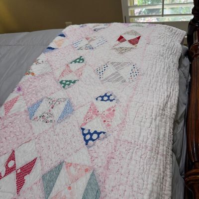 Sale Photo Thumbnail #53: Handmade vintage patch quilt featuring geometric block patterns in pink, white, blue, and red fabrics.