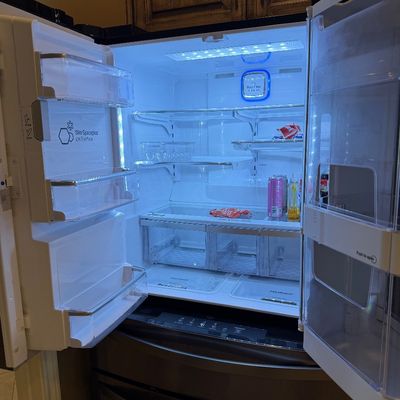 Sale Photo Thumbnail #11: Modern LG French door refrigerator featuring LED lighting, Slim SpacePlus ice system, and adjustable glass shelving, shown open and lit.