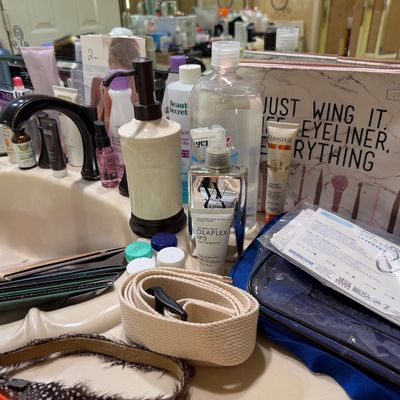 Sale Photo Thumbnail #30: Assortment of bathroom toiletries and cosmetic items, including an Olaplex hair treatment, Kerastase lotion, soap dispenser, and zippered makeup pouch.