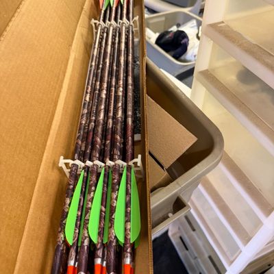Sale Photo Thumbnail #106: Set of Easton Superlite camouflage archery arrows with green and orange fletchings, stored in their original cardboard box.