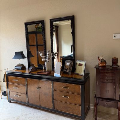 Sale Photo Thumbnail #17: Large Asian-inspired burl wood and black lacquer credenza with matching dual wall mirrors, displayed alongside a freestanding wooden jewelry armoire.