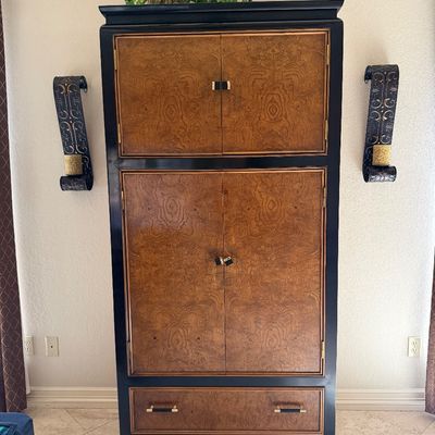 Sale Photo Thumbnail #14: Asian-inspired armoire featuring burl wood door and drawer fronts set in a black frame, flanged top, and brass hardware.