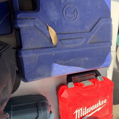 Sale Photo Thumbnail #96: Collection of hard plastic tool storage cases, including a red Milwaukee case, showing light wear and dust from use.