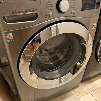 Sale Photo Thumbnail #67: Modern silver LG Direct Drive front-load washing machine with steam cycle option.