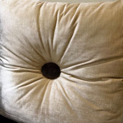 Sale Photo Thumbnail #63: Cream-colored velvet tufted accent pillow featuring a central dark brown fur-covered button.