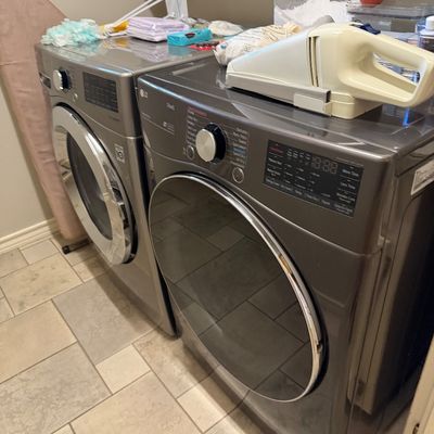 Sale Photo Thumbnail #66: Matching side-by-side LG front-load washer and dryer set in graphite steel finish, featuring digital controls and chrome trim.