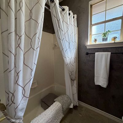 Sale Photo Thumbnail #59: Bathroom setup featuring white grommet shower curtains with a beige geometric chain pattern, matching rope tiebacks, and assorted bath linens in a bathtub.