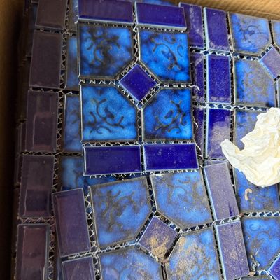 Sale Photo Thumbnail #103: Box containing sheets of cobalt blue mesh-backed mosaic pool tiles featuring a geometric pattern with patterned accent pieces.