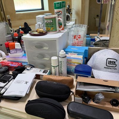 Sale Photo Thumbnail #31: Assorted bathroom counter items, personal care products, eyewear cases, and a Glock Perfection baseball cap.