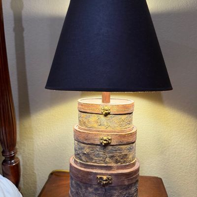 Sale Photo Thumbnail #54: Novelty table lamp featuring a stacked faux-miniature trunk base with brass-tone latches and a black fabric shade.