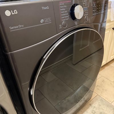 Sale Photo Thumbnail #68: Modern LG ThinQ Sensor Dry front-loading clothes dryer in dark metallic gray finish.