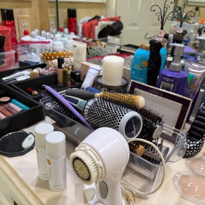 Sale Photo Thumbnail #29: Assorted vanity, beauty, and hair care supplies, including a Clarisonic facial cleansing brush, round styling brushes, makeup organizers, and toiletries.