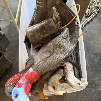 Sale Photo Thumbnail #105: Collection of inflatable turkey and goose hunting decoys stored in a plastic tote, including heads, bodies, and a small inflation canister.