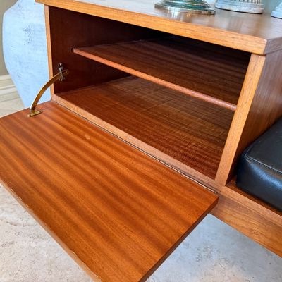 Sale Photo Thumbnail #3: Mid-century Danish modern style teak telephone bench featuring an open drop-down cabinet storage compartment and an integrated black vinyl seat.