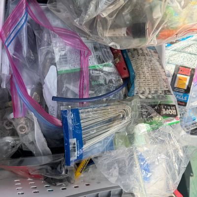 Sale Photo Thumbnail #94: Assorted hardware and workshop supplies contained in plastic storage bags, including metal landscape staples, rope, and miscellaneous small parts.