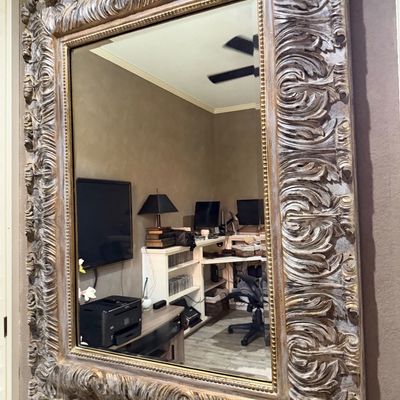Sale Photo Thumbnail #75: Large ornate wall mirror featuring a heavily carved acanthus leaf frame in a silver and gold distressed finish.
