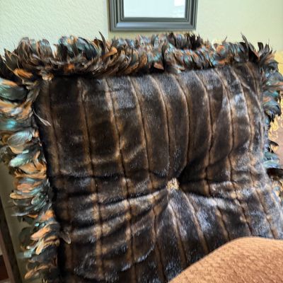 Sale Photo Thumbnail #60: Luxurious dark brown fur throw pillow with iridescent feather trim and a center button accent.