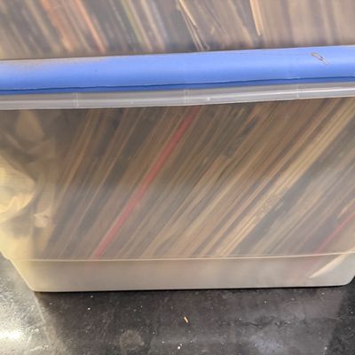 Sale Photo Thumbnail #110: Large clear plastic storage bin filled with vinyl LP records, stacked closely together.