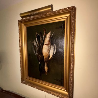 Sale Photo Thumbnail #5: Framed still life oil painting depicting hunted waterfowl, presented in an ornate gilt wood frame with an attached brass picture light.