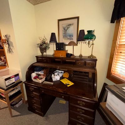 Sale Photo Thumbnail #27: Traditional dark wood roll-top desk with multiple drawers, interior cubbies, and tabletop lamps and decor.