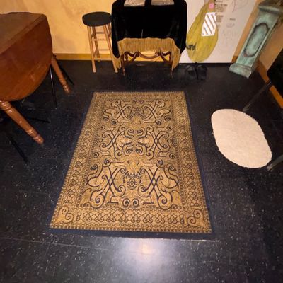 Sale Photo Thumbnail #117: Traditional patterned area rug in gold and dark blue shades set on dark flooring surrounded by assorted furniture.