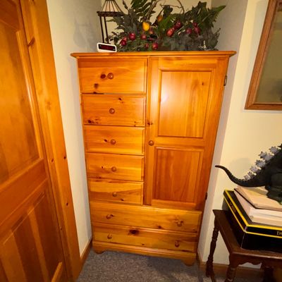 Sale Photo Thumbnail #26: Tall rustic knotty pine armoire dresser featuring six stacked drawers, a panel cabinet door, and two wide bottom drawers.