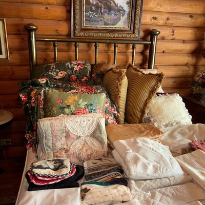 Sale Photo Thumbnail #57: Brass full or queen bed frame displayed with assorted linens, including floral comforters, decorative pillows, quilts, and towels.