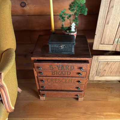 Sale Photo Thumbnail #62: Antique wooden spool cabinet labeled "5-Yard Braid Crescent," repurposed as a small side table or chest of drawers.
