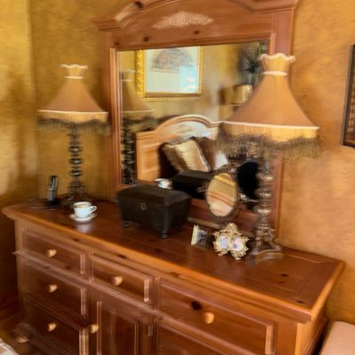 Sale Photo Thumbnail #42: Pine dresser with attached arched mirror, flanked by a pair of ornate table lamps with fringe-trimmed shades.