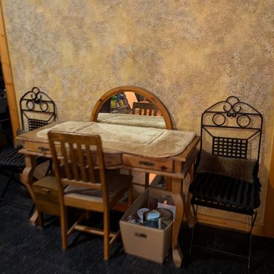 Sale Photo Thumbnail #25: Rustic light wood vanity desk with arched mirror and matching wooden chair, flanked by two wrought iron side chairs.