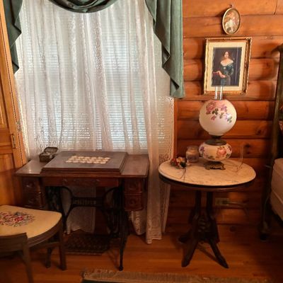 Sale Photo Thumbnail #73: Vintage treadle sewing machine cabinet with wrought iron base alongside an antique marble-top accent table and floral painted gone-with-the-wind style lamp.