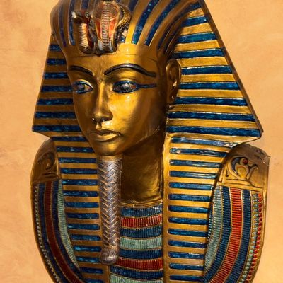 Sale Photo Thumbnail #112: Egyptian Revival King Tutankhamun mask wall hanging, rendered in gilded composite with hand-painted blue and red accents.