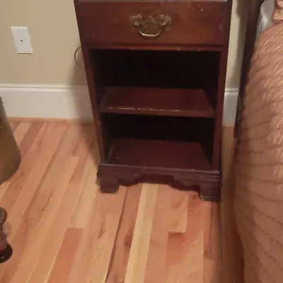 Traditional dark wood nightstand featuring a single drawer with brass hardware and open lower shelves.