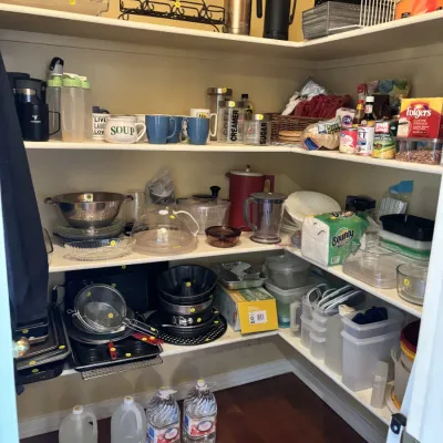 Sale Photo Thumbnail #10: Walk-in kitchen pantry filled with assorted housewares, cookware, food storage containers, and pantry staples.