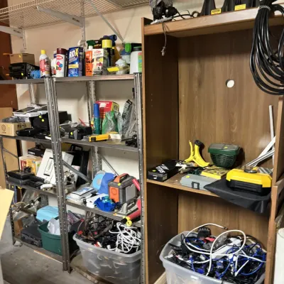Sale Photo Thumbnail #4: Garage storage organization setup featuring metal shelving units, a tall faux-wood cabinet, and plastic storage totes filled with assorted tools, cleaning supplies, and electrical cords.