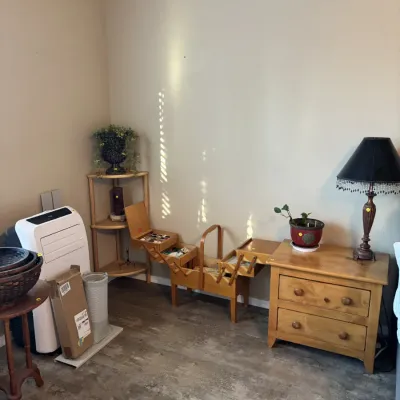 Sale Photo Thumbnail #21: Vintage accordion-style wooden sewing box sitting alongside a two-drawer light wood nightstand, a portable air conditioner, and corner shelving.
