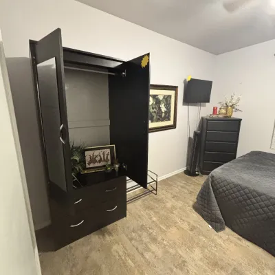 Sale Photo Thumbnail #33: Contemporary dark espresso wardrobe armoire featuring two upper doors and lower storage drawers, set alongside matching bedroom furniture.