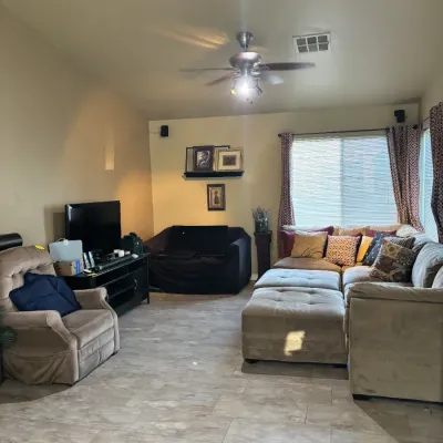 Sale Photo Thumbnail #36: Spacious living room set including a beige tufted sectional couch with matching ottomans, a plush beige armchair, a dark wood TV console with flat-screen television, and a dark upholstered love seat.