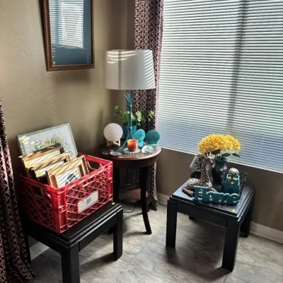 Sale Photo Thumbnail #39: A collection of home decor items, including a red crate filled with picture frames, dark wooden end tables, a table lamp, and decorative accents.