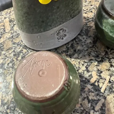 Sale Photo Thumbnail #14: Handcrafted studio pottery vessel shown upside down, displaying an incised artist signature on the unglazed clay base.