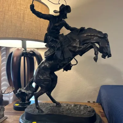 Sale Photo Thumbnail #2: Bronze reproduction sculpture of Frederic Remington's "Bronco Buster" mounted on a green marble base.