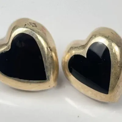 Pair of Sterling Silver heart-shaped stud earrings featuring polished black onyx inlays.