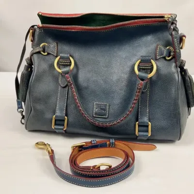 Dooney & Bourke navy blue Florentine leather satchel with braided handles, gold-tone hardware, and an optional shoulder strap.