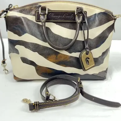 Dooney & Bourke zebra-print leather satchel with dark brown trim, top handles, key fob, and detachable shoulder strap.
