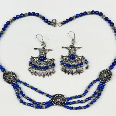 Ethnic style cobalt blue beaded jewelry set, featuring a multi-strand draped necklace and matching dangle earrings with ornate metal...